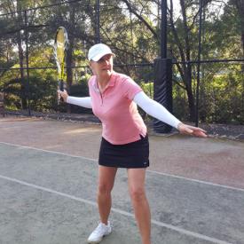 A woman about to hit a forehand tennis stroke wearing IceRays Sun Sleeves to protect her arms from the sun while playing tennis. Sun Protection! Tennis 