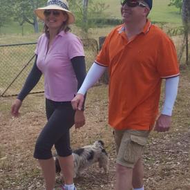 A couple out for a walk with their dog, and both the man and the woman are wearing IceRays Sun Sleeves for Maximum UV sun protection while hiking. Walking 